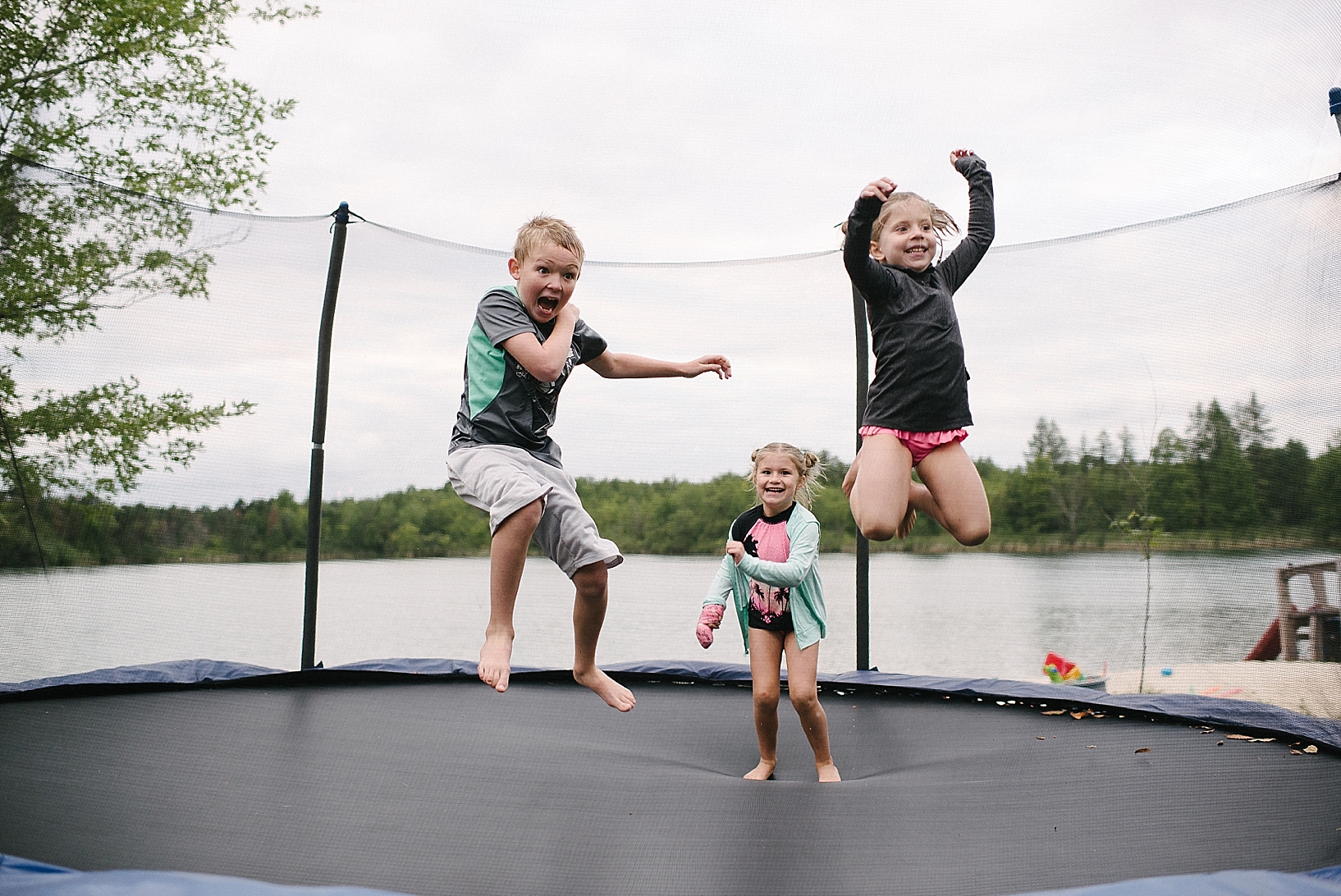 three kids jumping on trampoline