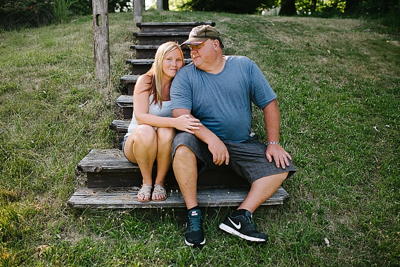 wife and husband sitting on wooden steps in backyard