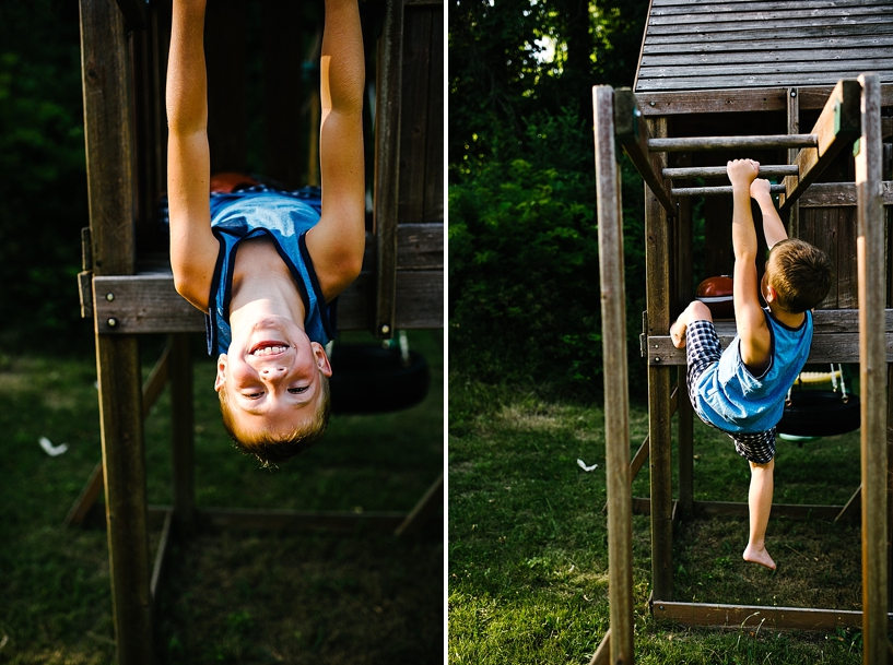 little boy hanging upside down on monkey bars
