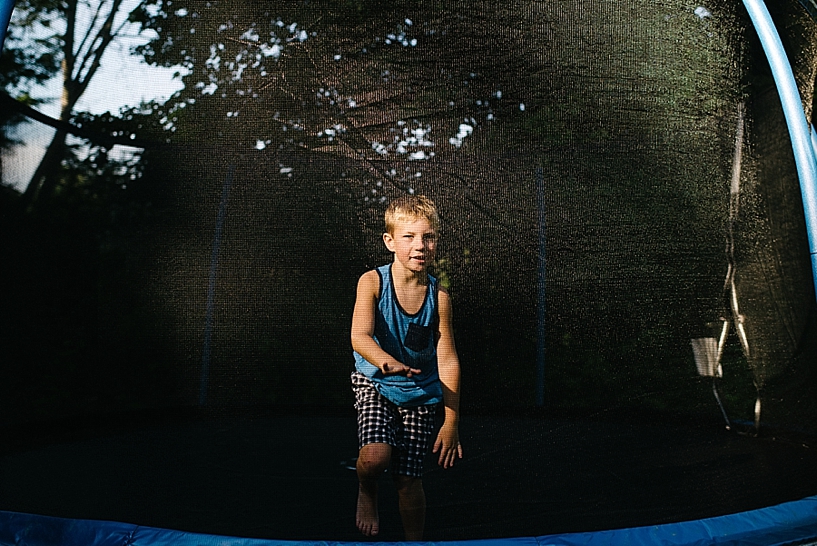 little boy on trampoline with sunlight and shadows