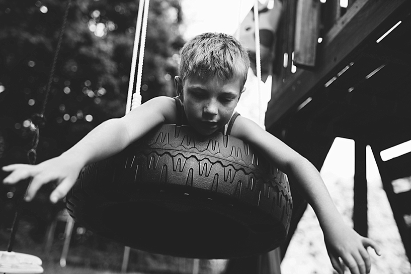 little boy swinging on tire swing