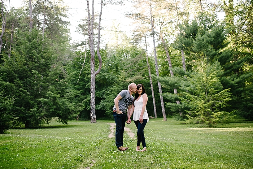 engaged couple standing in field