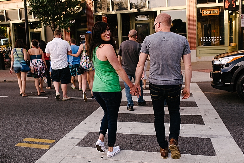 couple holding hands walking in crosswalk downtown cleveland
