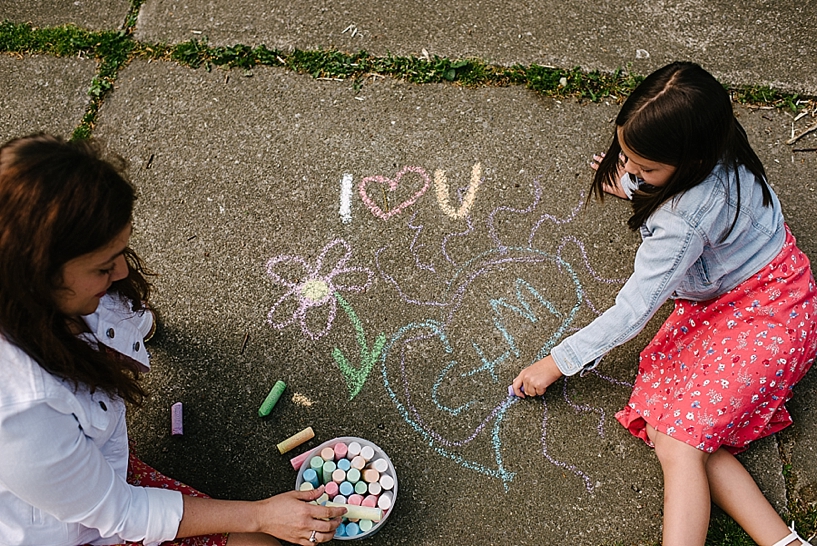 mom and daughter drawing with chalk on driveway
