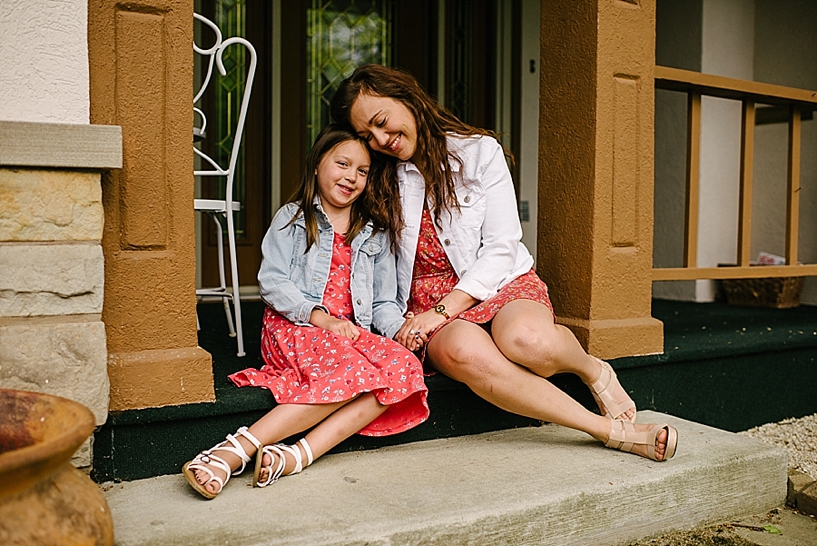 mom and daughter sitting on front steps of home