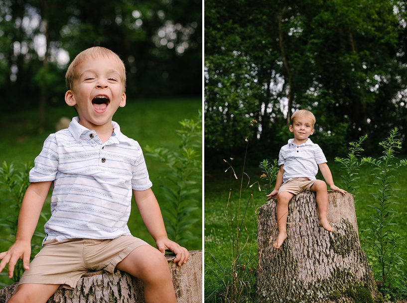 boy sitting on tree stump with hands in the air