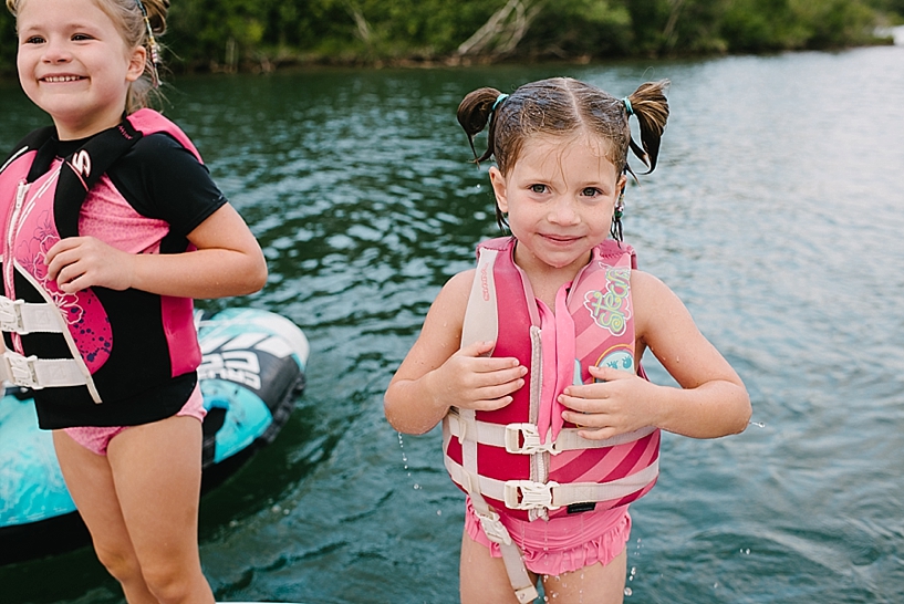 little girl wearing life jacket at the lake