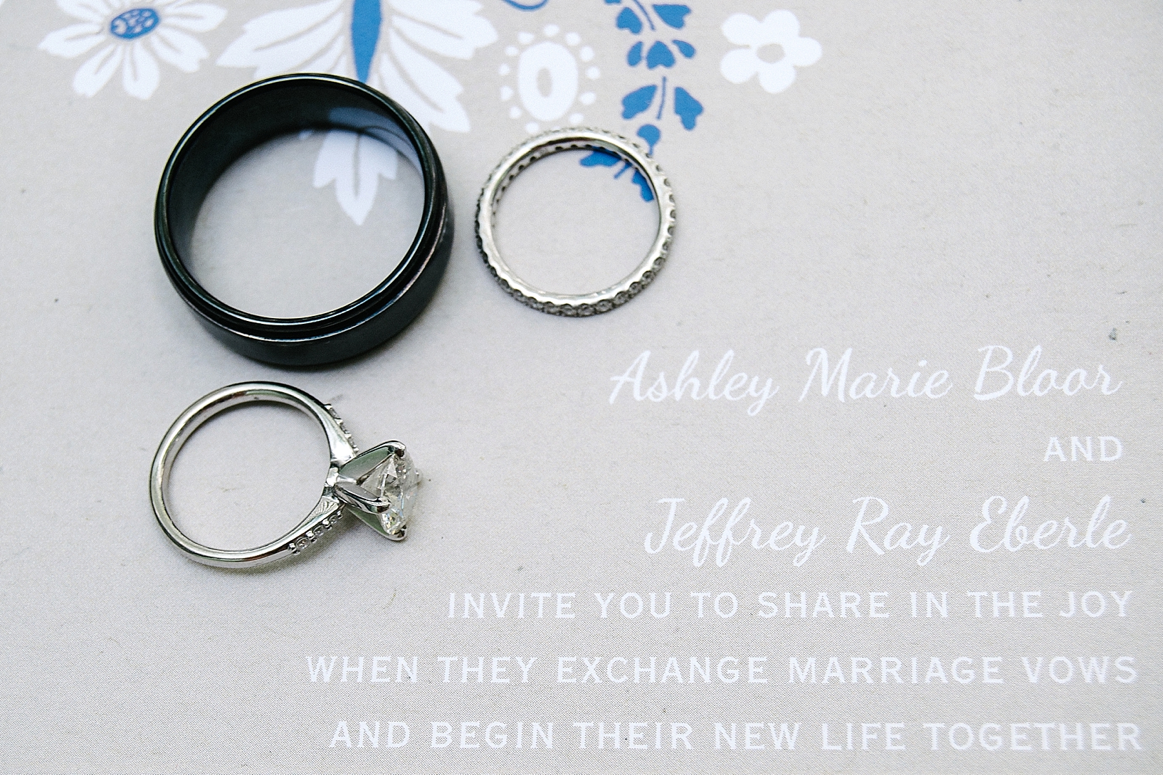 wedding rings on navy and white invitation