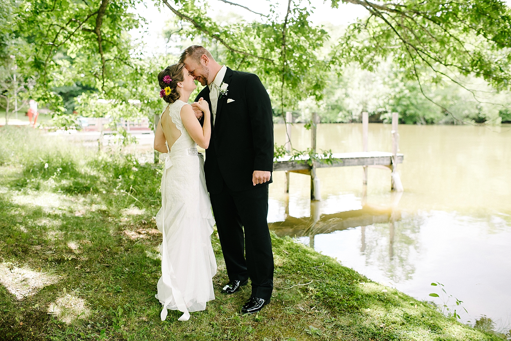First Look between bride and groom by lake with pier