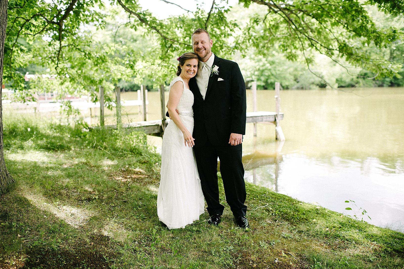 First Look between bride and groom by lake with pier