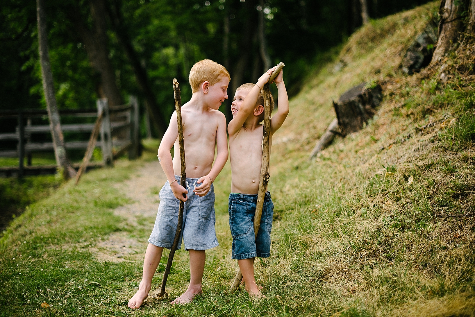 brothers with walking sticks and no shirts laughing