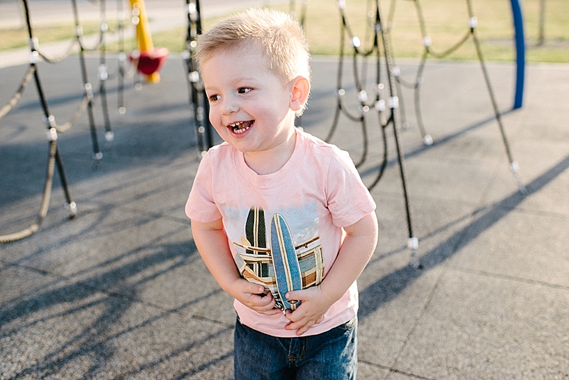 toddler boy laughing on playground