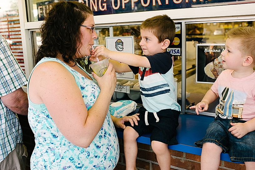toddler helping mom drink lemonade at Handel's Ice Cream