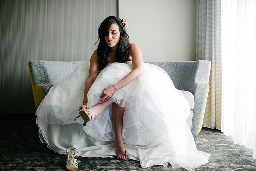 bride in poofy dress putting on her shoes