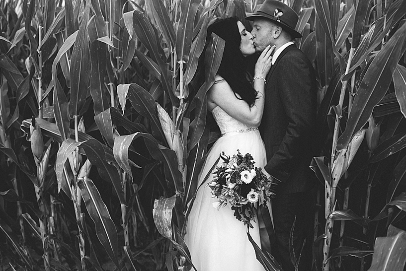 bride and groom kissing in corn maze