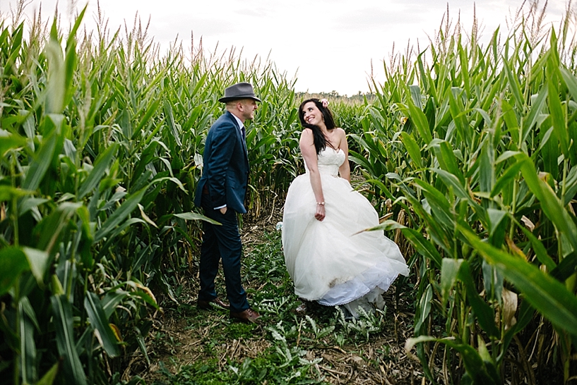 bride twirling her dress for groom in corn maze