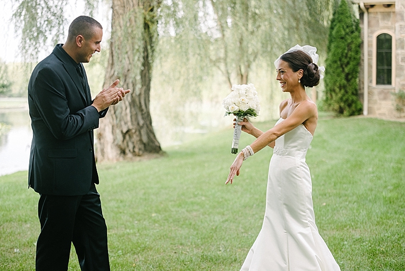 bride shows off her jewelry to groom seeing her for the first time