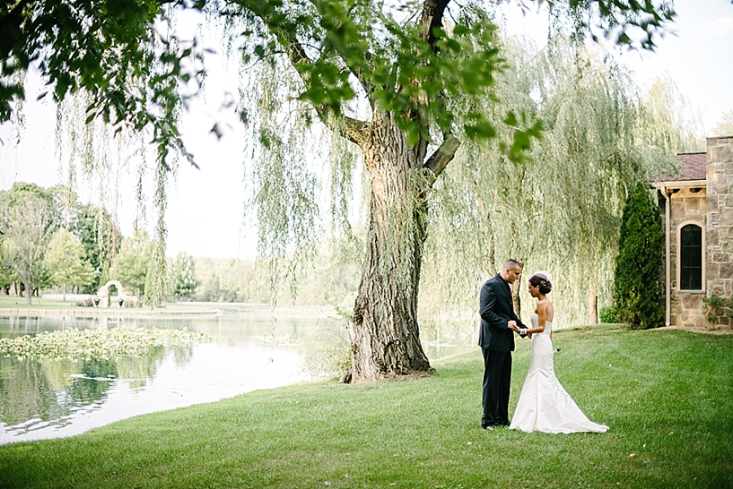 bride and groom pray underneath willow tree