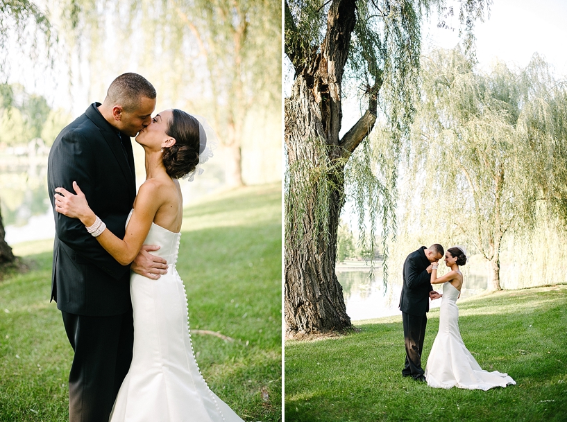 bride and groom kissing under willow tree by lake