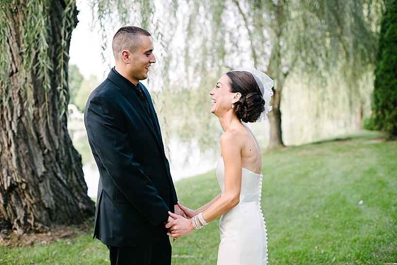 bride and groom laughing together by willow trees