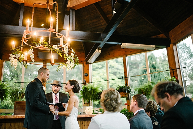 bride and groom holding hands during ceremony at Gervasi Vineyard Conservatory
