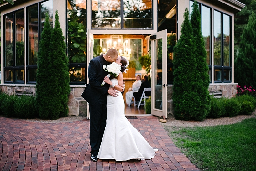 bride and groom kiss outside of Conservatory