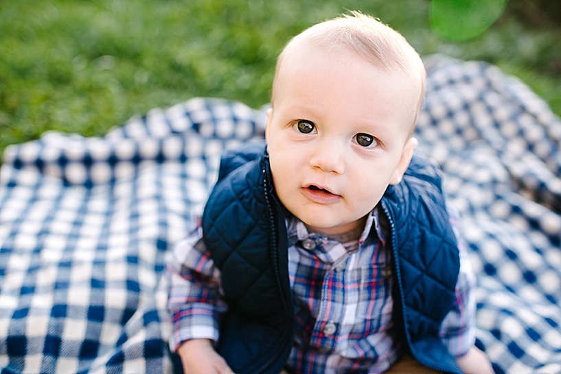 6 month old little boy in plaid shirt sitting on blue and white checked blanket