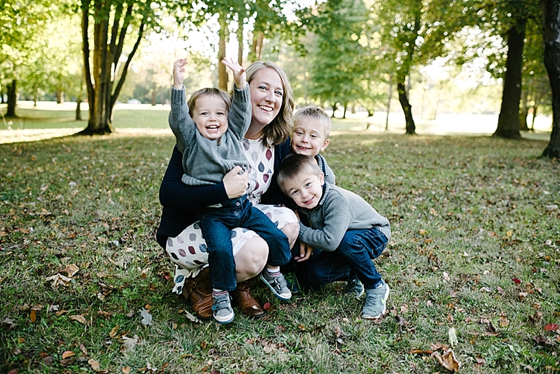 mom kneeling with three sons gathered around her
