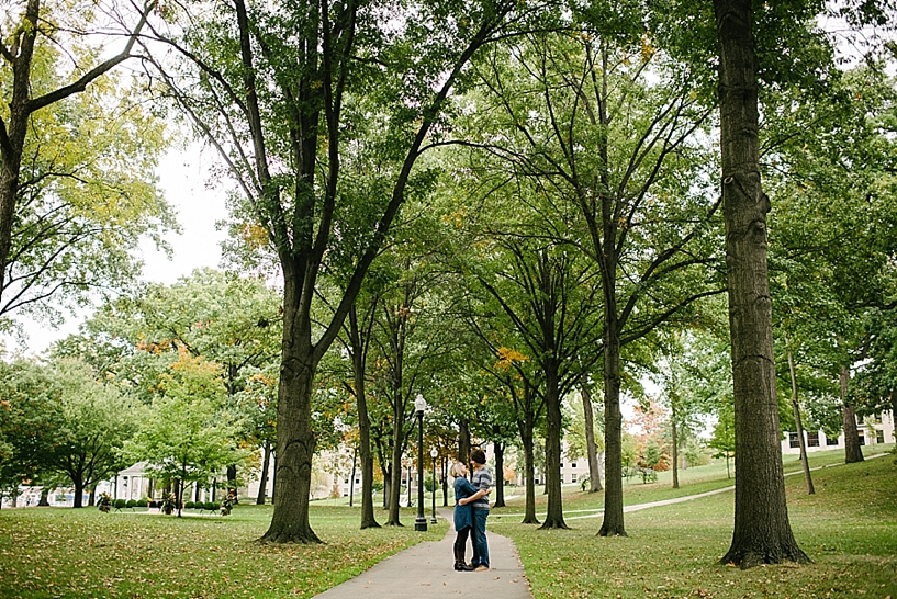 couple standing on sidewalk hugging in the middle of Kent State University campus