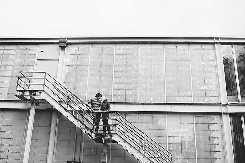 guy and girl standing on fire escape on the back of yellow art building on Kent State University