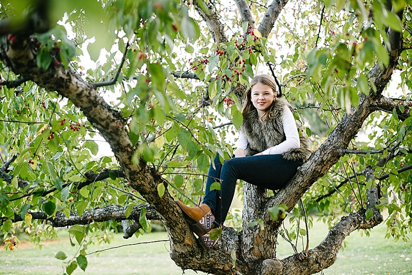 girl sitting in apple tree