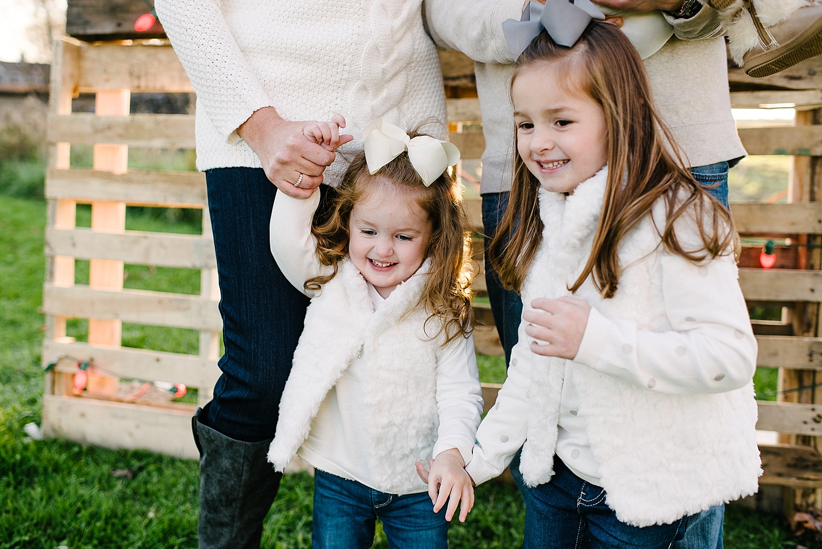 family with three girls wearing cream sweaters