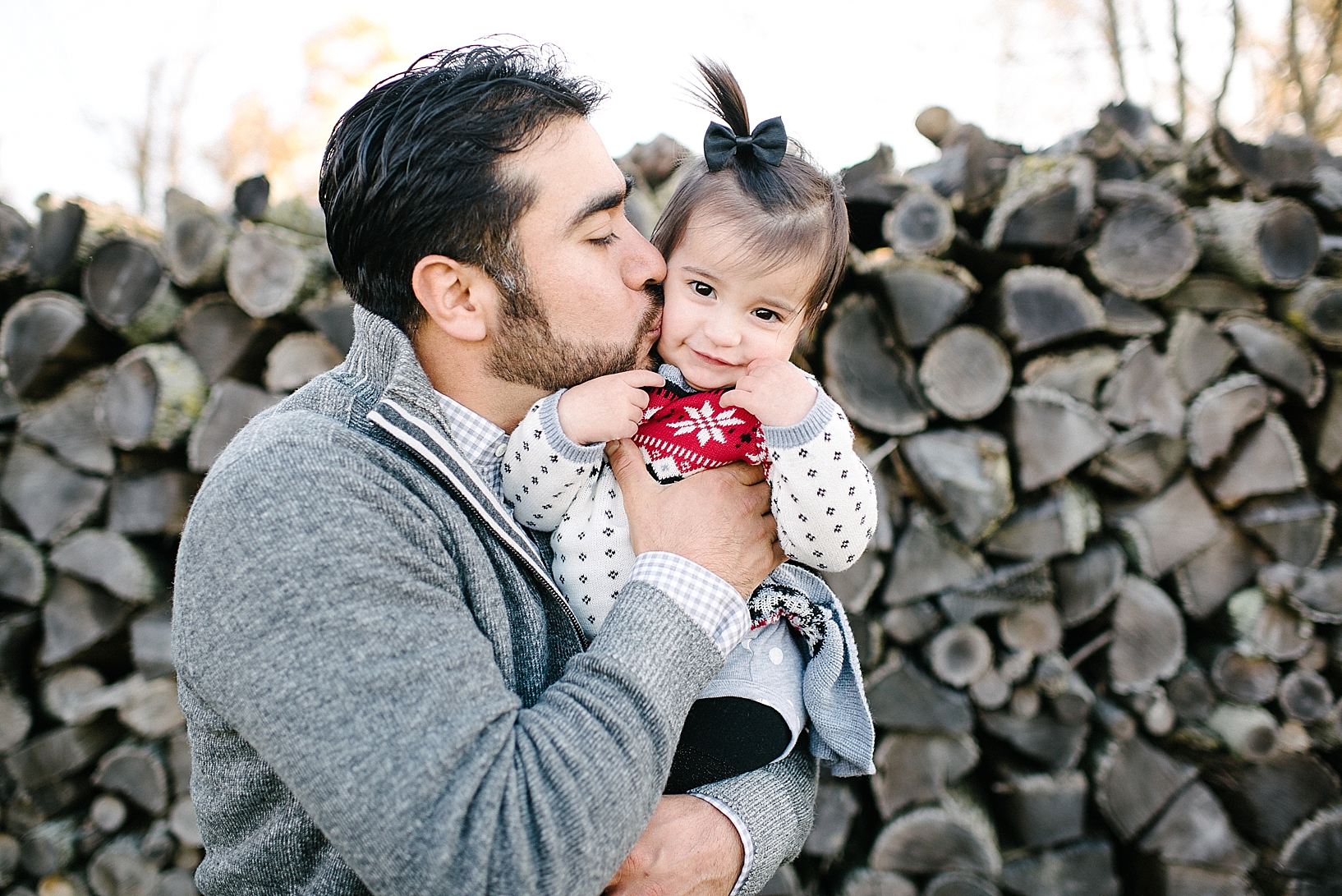 dad kissing daughter on the cheek