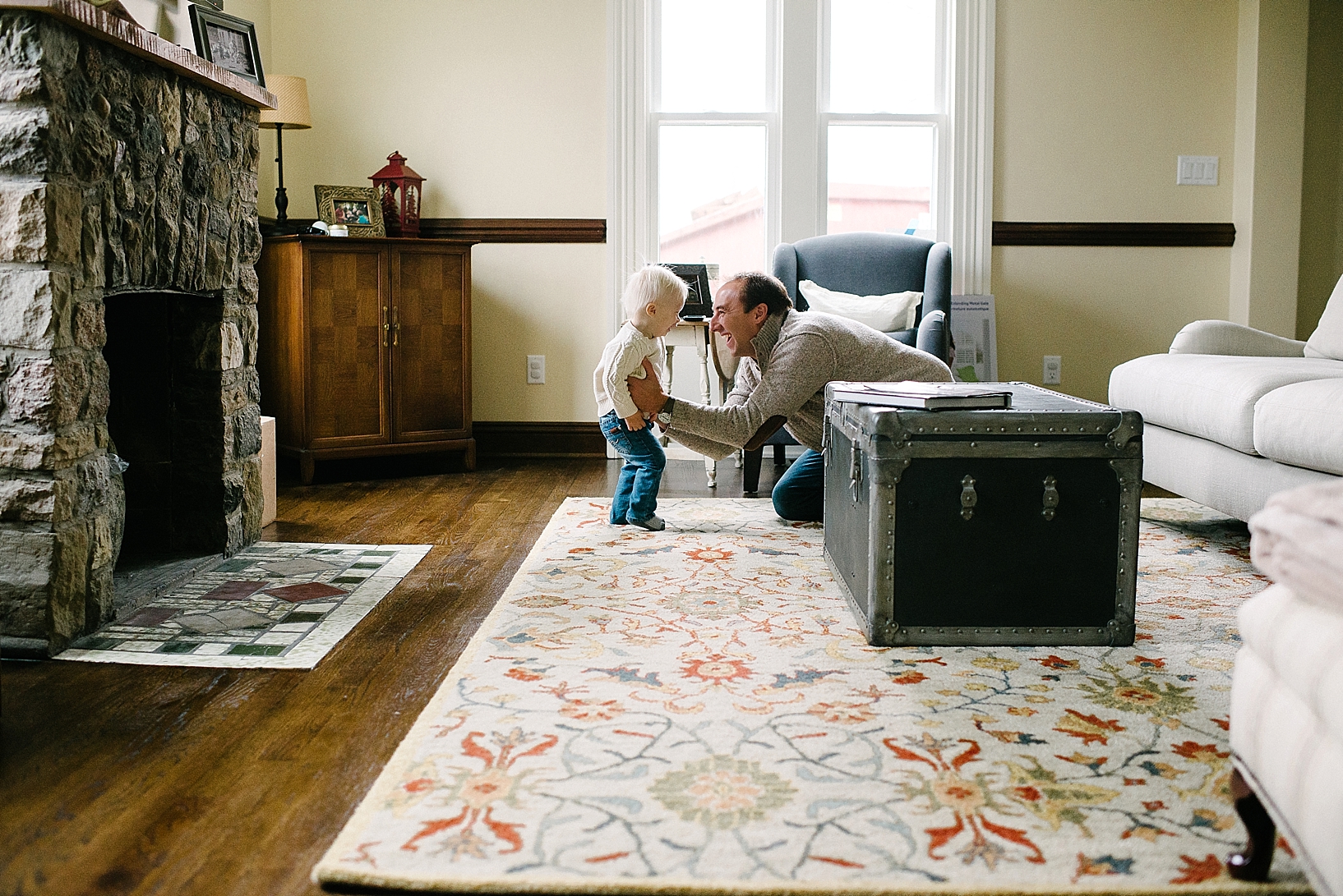 dad sitting on living room floor with toddler son