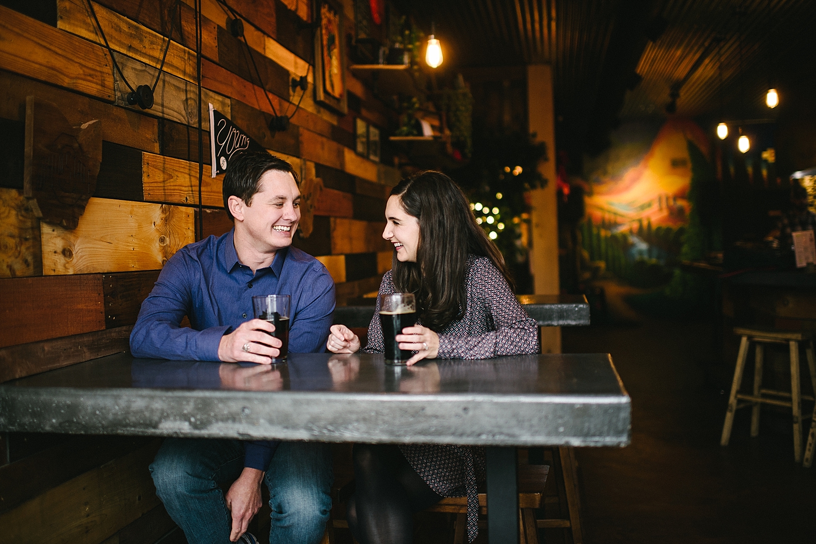 couple sitting inside Birdfish Brewing Co drinking craft beer at high top table