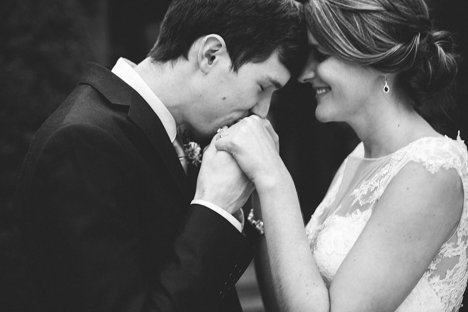 groom kissing bride's hands