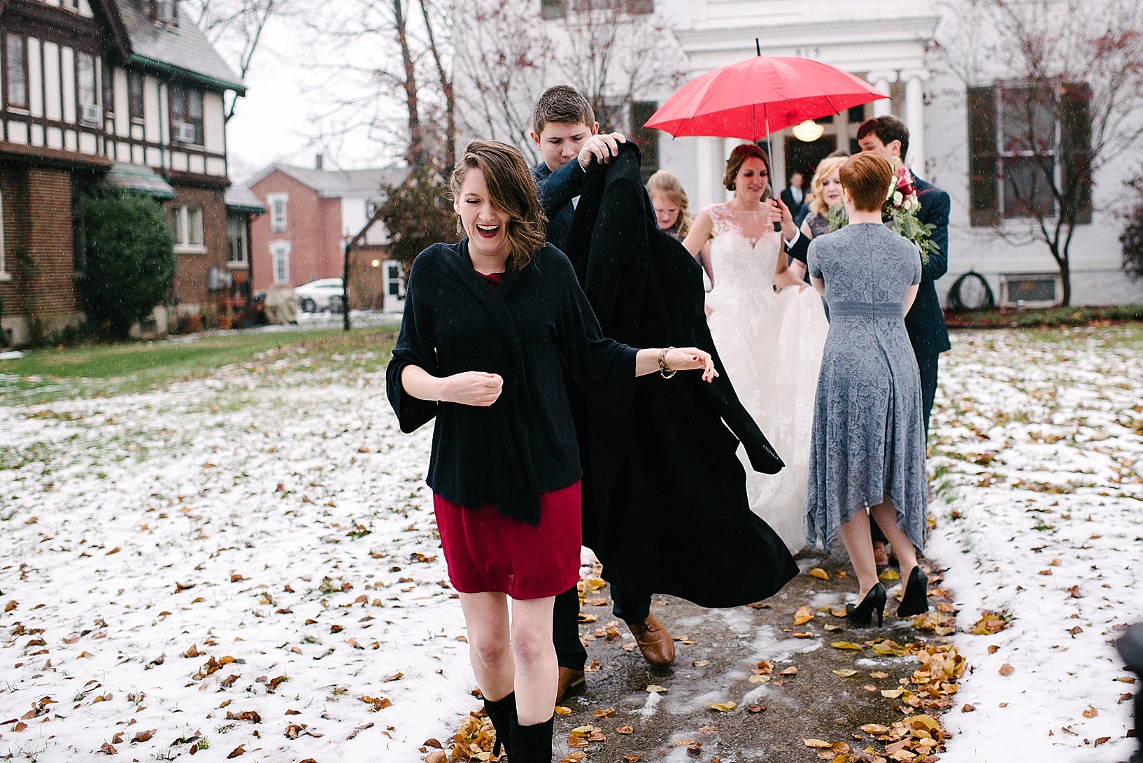 bridal party walking up snowy sidewalk laughing