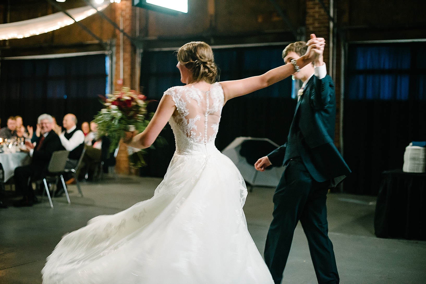 bride and groom holding hands entering wedding reception