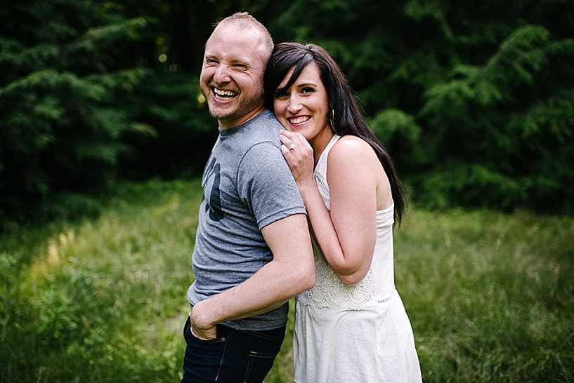woman leaning against man's back smiling and laughing