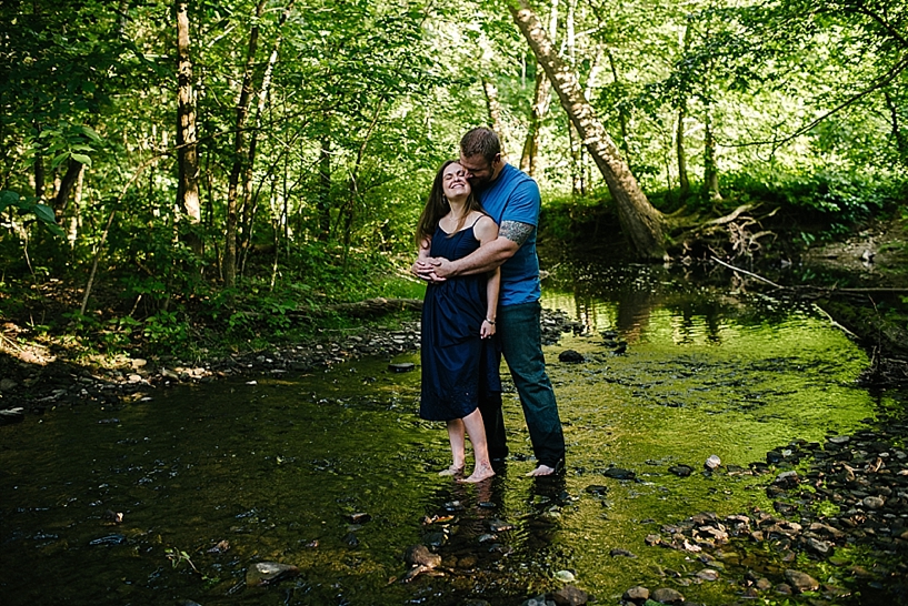 couple standing in river embracing 
