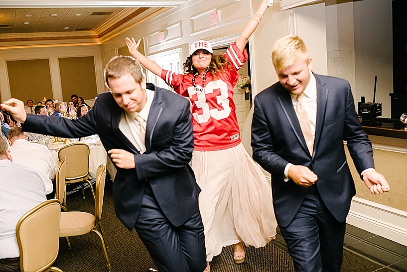 bridesmaid wearing Ohio State Buckeyes jersey entering reception with groomsmen