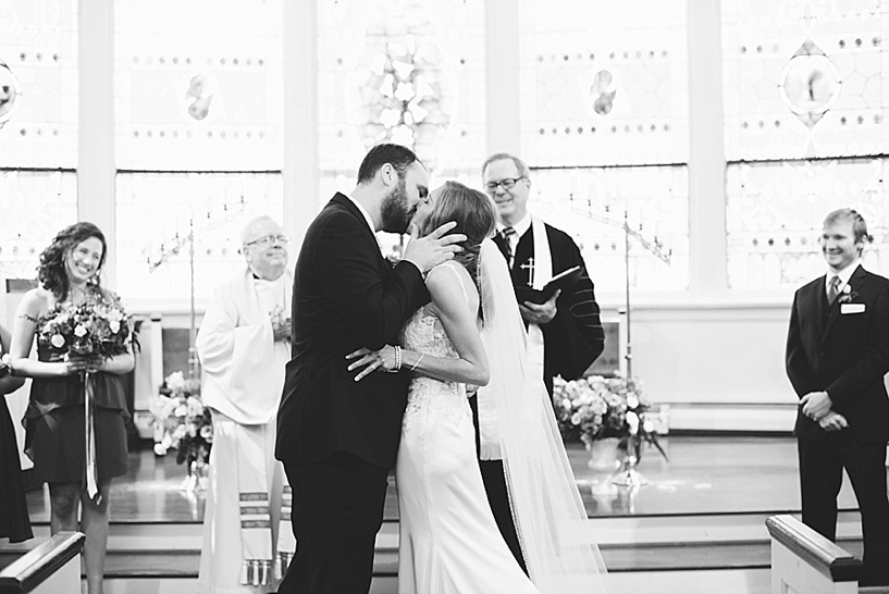 bride and groom kiss during church wedding ceremony