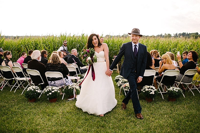 bride and groom walk down the aisle at corn maze wedding