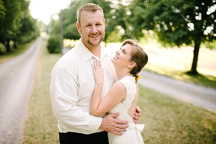 groom hugs bride while she smiles up at him