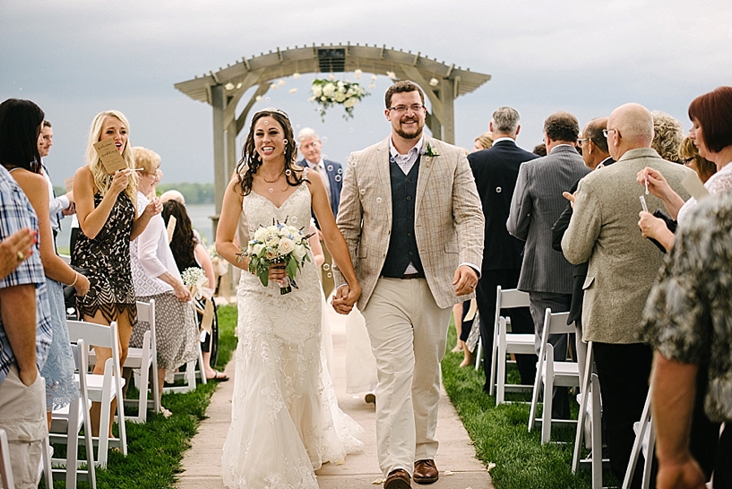 bride and groom walk up aisle at outdoor ceremony at Vineyards at Pine Lake