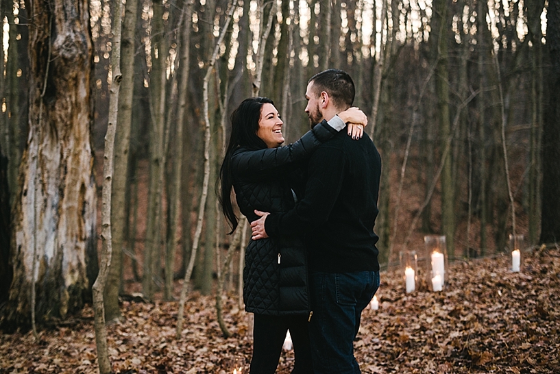 couple hugging in woods after getting engaged