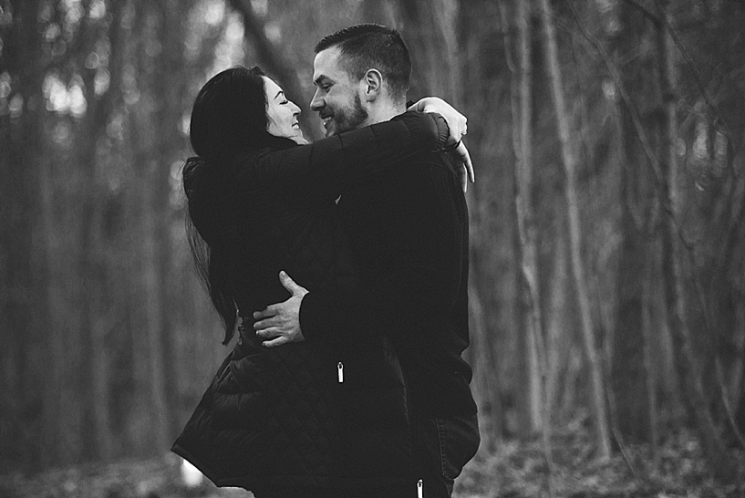 couple hugging and smiling in winter woods