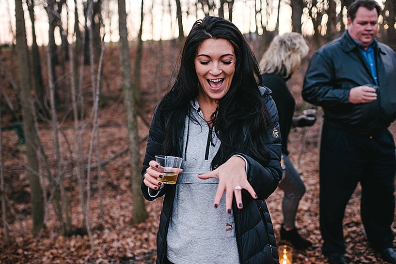 newly engaged woman holding champagne and looking at her ring