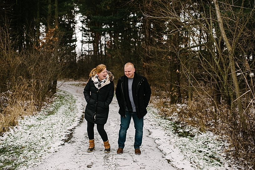couple in winter coats walking on snowy trail