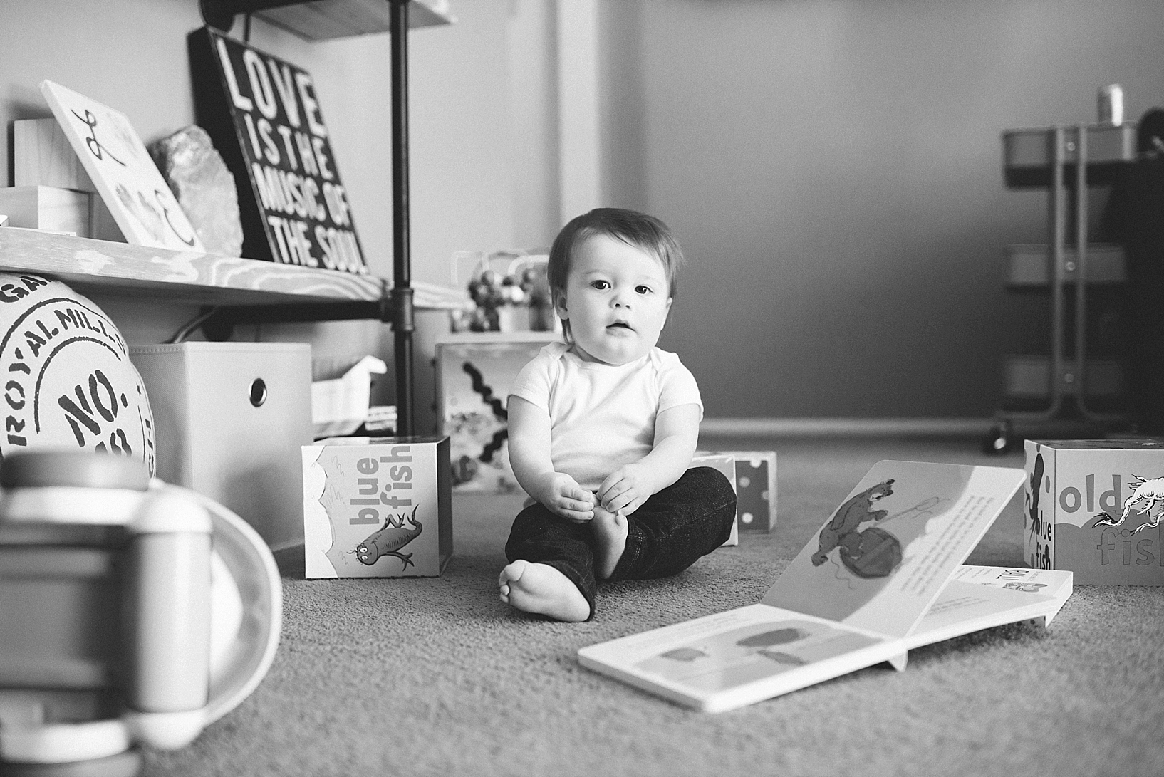 toddler boy sitting on living room floor surrounded by toys